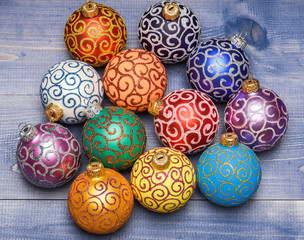 Christmas ornaments decorations on vintage wooden background. Christmas decorations concept. Pick colorful decorations. Modern christmas decor. Balls with glitter and shimmering decorative ornaments
