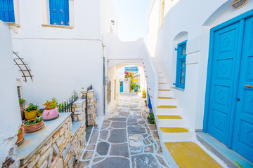 Colorful stairs in narrow street with white houses and blue colored windows. Old rustic Greek house...