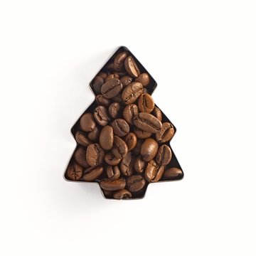 Coffee beans in the shape of a Christmas tree isolated on white background. Top view
