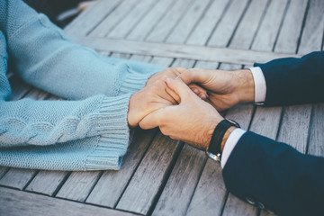 Closeup of young couple holding their hands