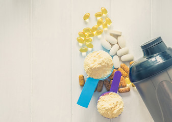 Sport food supplements. Sport Pills, vitamins and protein powder with bottle composed on the white table