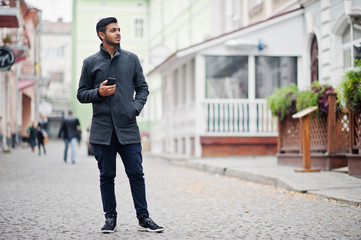 Stylish indian hindu man in gray coat posed on street.