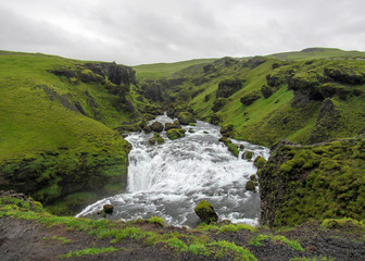 Fototapeta premium View on Skoga river with waterfall in rainy summer day on the Fimmvorduhals trail from Skogar to Thorsmork, Highlands of Iceland