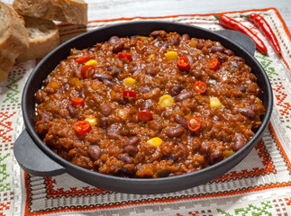 Texas chili. Chili con carne in frying pan on white wooden background. 
