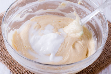 Mixing butter and sour cream in bowl with mixing machine
