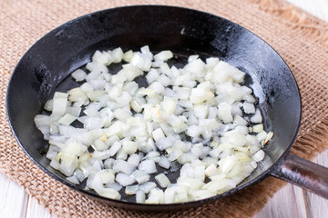 Fried onion in oil in a frying pan