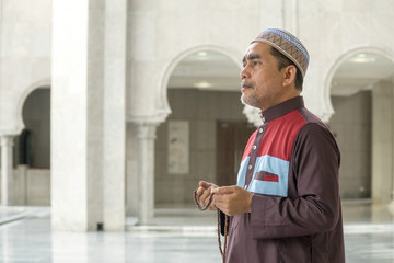 Middle age muslim man praying at mosque.