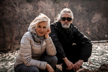 portrait of beautiful mature couple sitting on the rocks