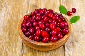 Autumn ripe cornel berries on wooden table
