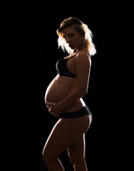 Obraz premium Artistic silhouette of blonde pregnant woman on isolated background