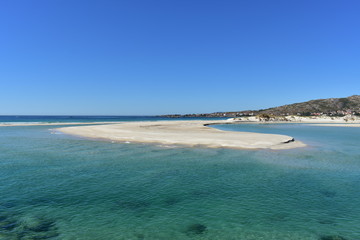 Beach with lake and turquoise water. Bright sand, dunes and blue sky. Galicia, Spain.