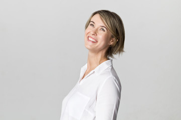 Amazing and cheerful smiling blonde in white shirt studio shot, isolated on white