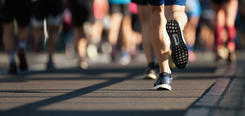 Marathon runners running on city road,detail on legs - obrazy, fototapety, plakaty