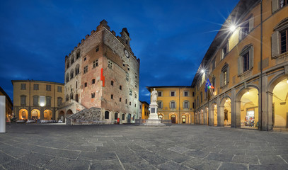 Prato, Italy. Panorama of Piazza del Comune square with historic building of medieval Town Hall at dusk