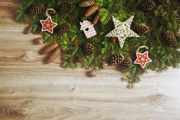 Christmas background with decorations and pine cones, on wooden board