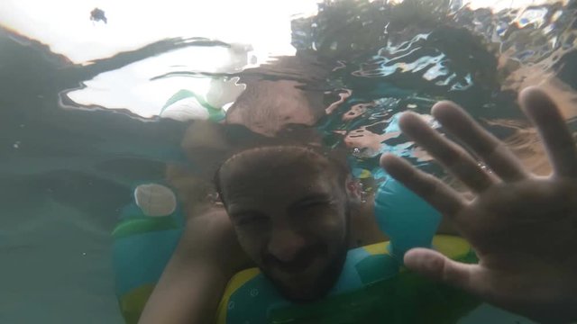 Underwater portrait of smiling man. Person having fun in swimming pool. Summer vacation concept. selphi.