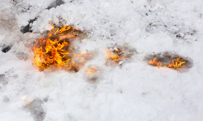 Flame of fire on white snow in winter