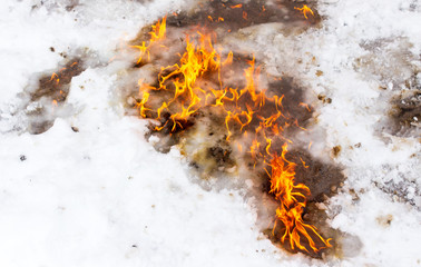 Flame of fire on white snow in winter