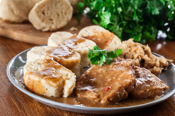 Pork loin in gravy with bread dumplings and sauerkraut