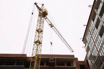 Construction of a residential multi-storey building. Working crane on the construction of the house