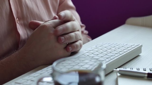 man works at a Desk and drinks coffee