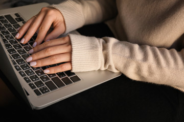 Woman using laptop at home, closeup