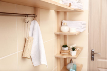 Rack with white terry towel and loofah in bathroom