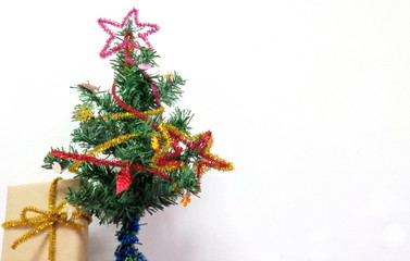 a small Christmas tree with a little gift box on the white background
