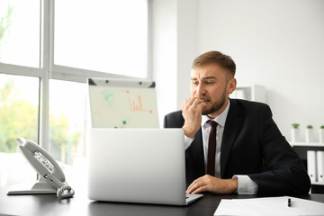Emotional young businessman after making mistake while working with laptop in office