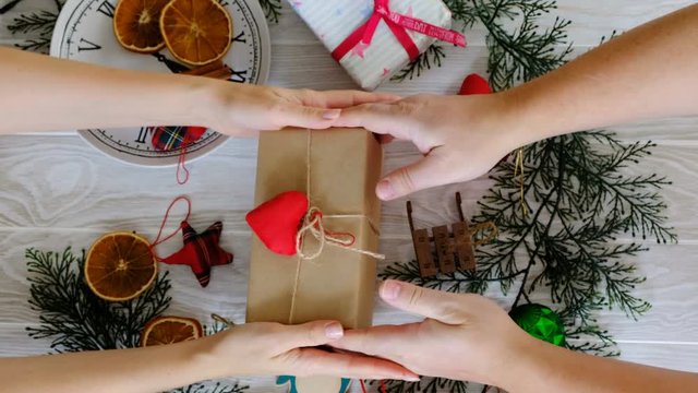 Human hands with Christmas gift, top view