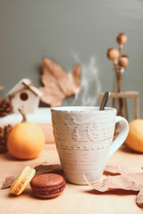 Cup of tea, macaroon and yellow pumpkin