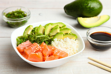 Hawaiian dish poke bowl on wooden background. Top view, copy space. 