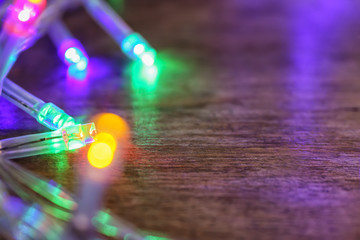 Glowing Christmas lights on table, closeup