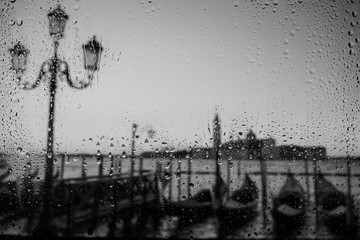 Venice Europe at rainy day weather water drops on the window with gondolas and sea on background