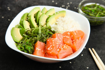 Hawaiian dish poke bowl on black background. 