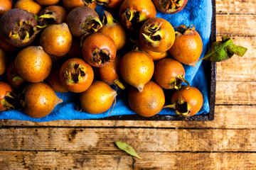 raw medlars on a rustic wooden table