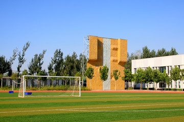 Football field and rock climbing facilities in a school