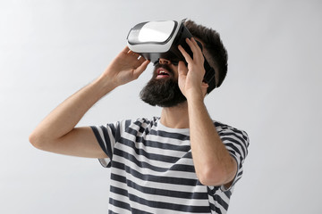 Obraz premium Man wearing virtual reality glasses on light background
