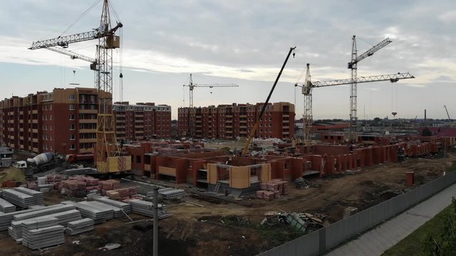 4k Aerial view of the city. Construction of residential buildings. Tower cranes working at a construction site