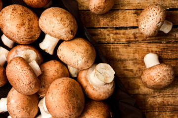 Fototapeta na wymiar Raw mushrooms on a rustic wooden table