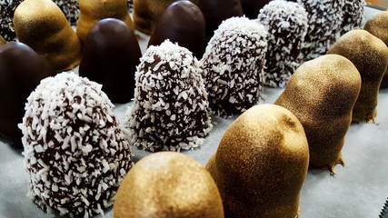 homemade chocolate cream puff (flødebolle) with coconut springle and gold dust - 234268931