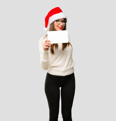 Girl with celebrating the christmas holidays holding an empty white placard for insert a concept on...