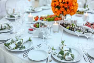 Holiday table setting decorated with flowers and candles.