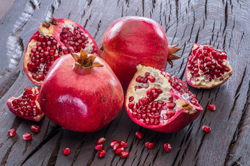 Ripe pomegranate fruits on the wooden background.