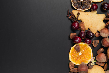 Christmas decorations background with copy space out of dry fruit, seasonal spices, nuts, home made cookies, top view, flat lay 