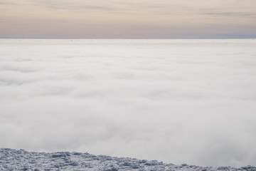 Naklejka na ściany i meble Above white heavy clouds. Panorama of cloudscape from the top of the mountain.