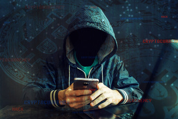 Anonymous hacker without a face is trying to steal cryptocurrency using a computer. Fraud and...