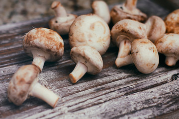 Fresh raw champignon mushrooms on wooden table. Cooking process. Modern kitchen.