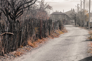 Village road with an old fence of branches on the sides