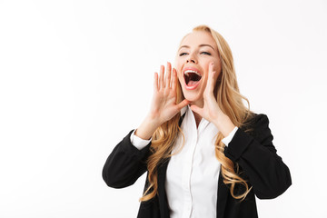 Photo of young businesswoman wearing office suit screaming or calling aside with hands at mouth, isolated over white background in studio